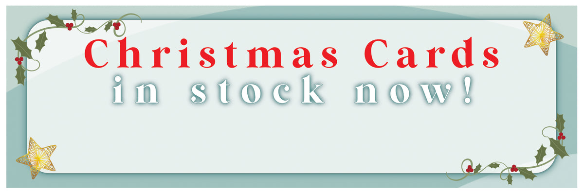 Promotional sign for Christmas cards in stock now with decorative elements.