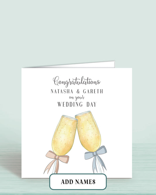 Wedding Day Card with Printed Champagne Glasses with Pink & Blue Bow. Words Read: Congratulations [Couples Names] on your Wedding Day.